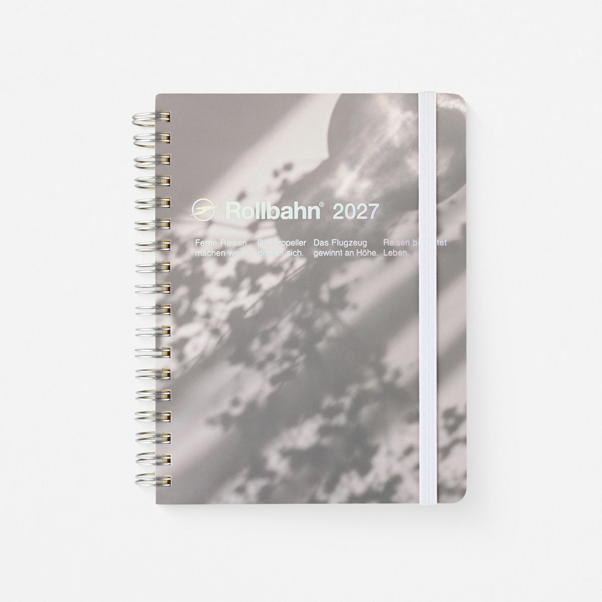2027 rollbahn planner Sunlight version c with photograph of sunlight casting shadows of vase and flowers with stainless steel spiral, white elastic band